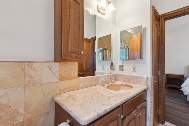 bathroom featuring vanity and tile walls