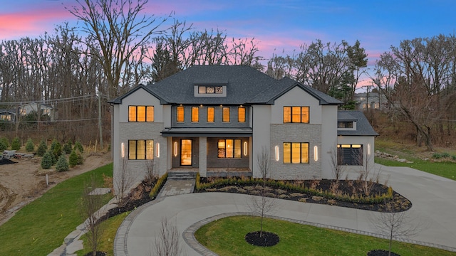 modern farmhouse with a lawn, a porch, and a garage