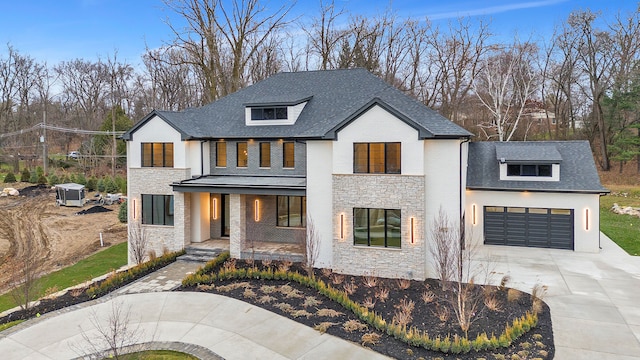 modern inspired farmhouse featuring covered porch and a garage