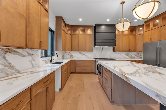 kitchen with sink, hanging light fixtures, light hardwood / wood-style floors, custom exhaust hood, and high end appliances