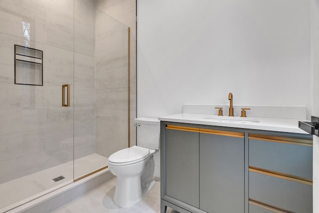 bathroom featuring tile patterned flooring, vanity, toilet, and a shower with shower door