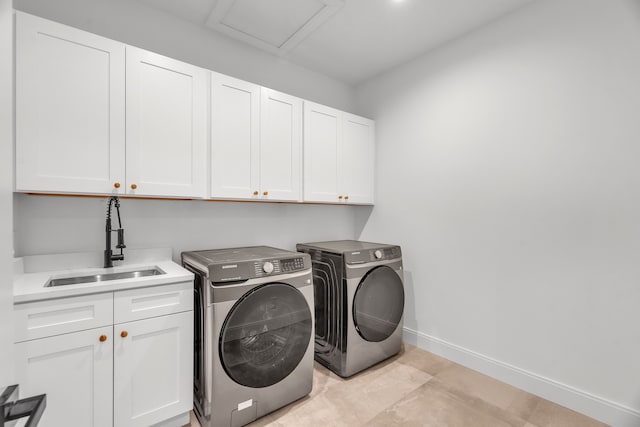 washroom featuring cabinets, light tile patterned floors, washing machine and clothes dryer, and sink