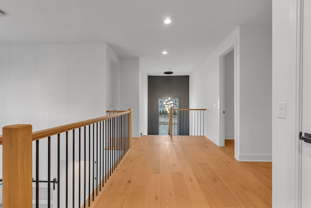 hallway featuring wood-type flooring and a notable chandelier