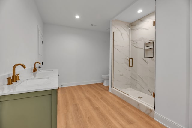 bathroom featuring vanity, hardwood / wood-style flooring, toilet, and a shower with shower door