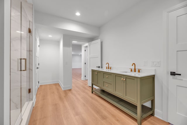 bathroom with hardwood / wood-style floors, vanity, and an enclosed shower