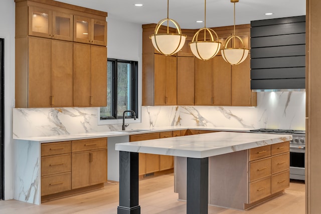 kitchen with decorative light fixtures, backsplash, stainless steel stove, and a kitchen island