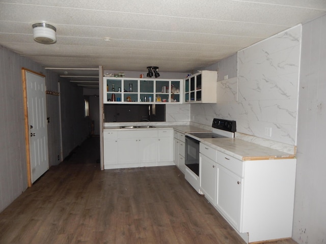 kitchen featuring dark hardwood / wood-style floors, white cabinetry, white electric range, and sink