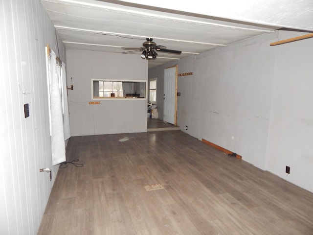 unfurnished living room with beam ceiling, ceiling fan, and hardwood / wood-style floors