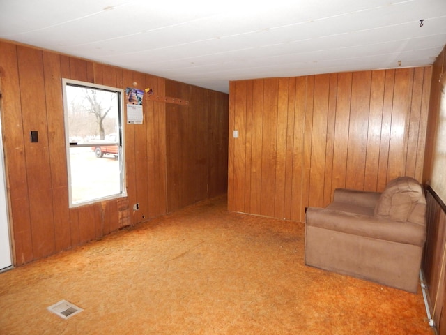 unfurnished room with wood walls and light colored carpet