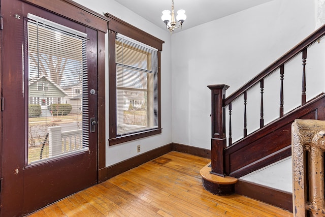 foyer entrance with light wood-type flooring and a notable chandelier