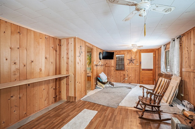 sitting room with ceiling fan and hardwood / wood-style flooring