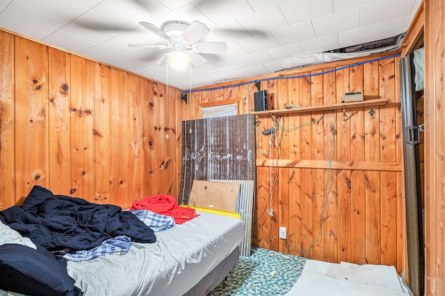 bedroom with wood walls and ceiling fan