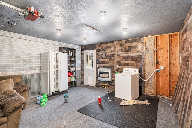 interior space featuring washer / clothes dryer, heating unit, wood walls, and brick wall