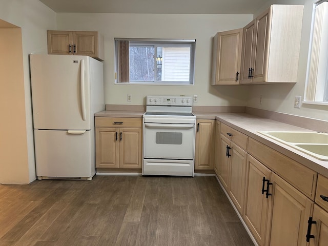 kitchen with white refrigerator, light brown cabinetry, and electric range