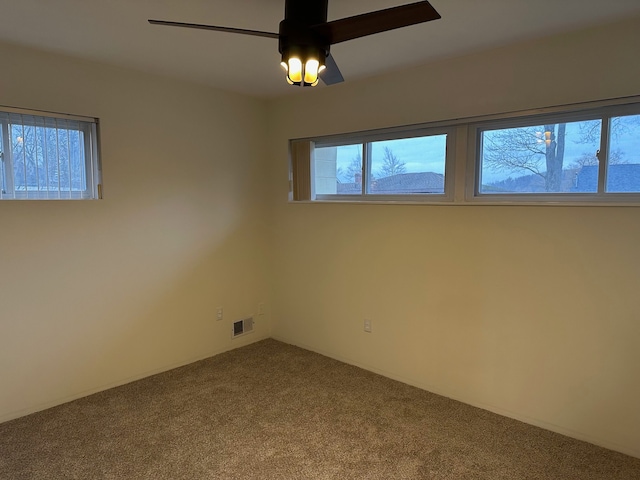 carpeted spare room featuring ceiling fan