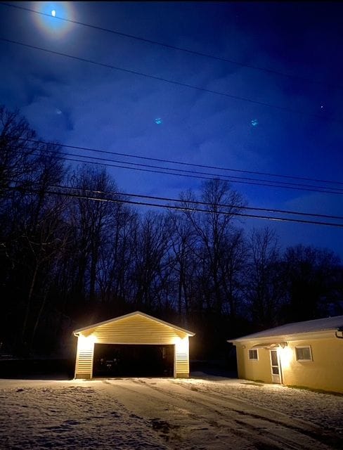 view of garage at twilight