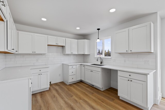 kitchen with white cabinets, pendant lighting, and sink