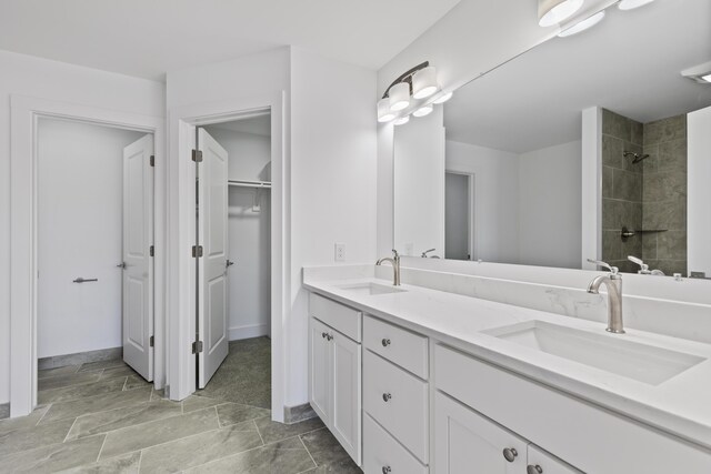 bathroom featuring tiled shower and vanity