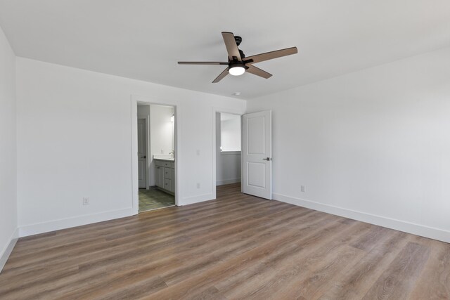 unfurnished bedroom with wood-type flooring, ensuite bath, and ceiling fan