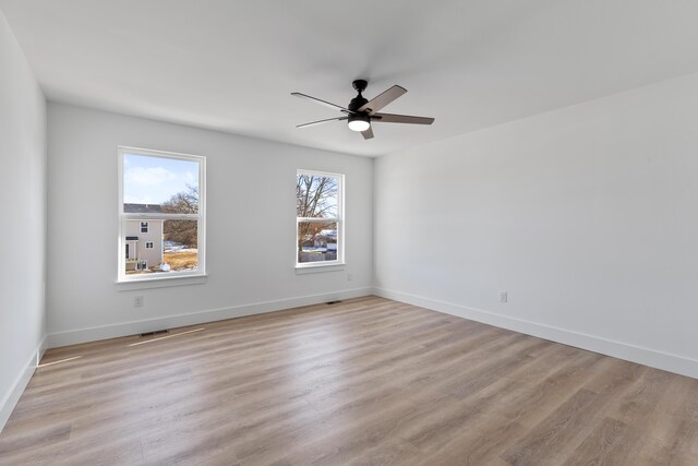 spare room with light wood-type flooring and ceiling fan