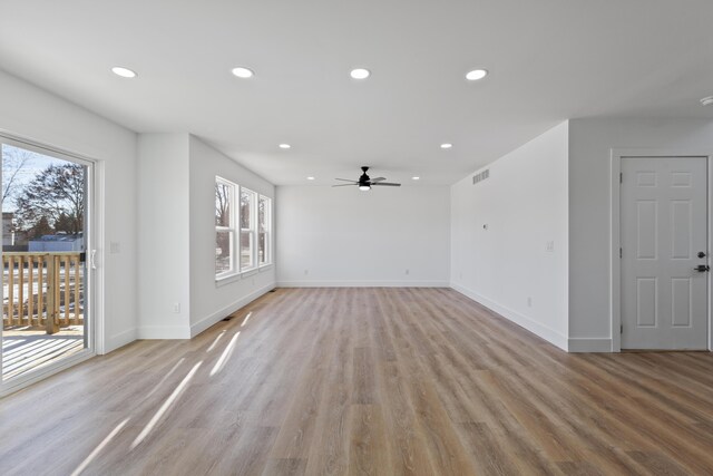 unfurnished living room with ceiling fan, a healthy amount of sunlight, and light wood-type flooring