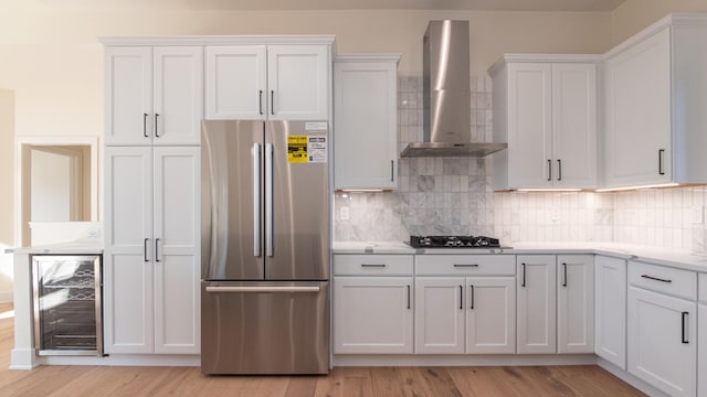 332 Arbor Ln, Saline, MI 48176 - kitchen with freestanding refrigerator, wall chimney exhaust hood, beverage cooler, gas cooktop, and light wood-style floors