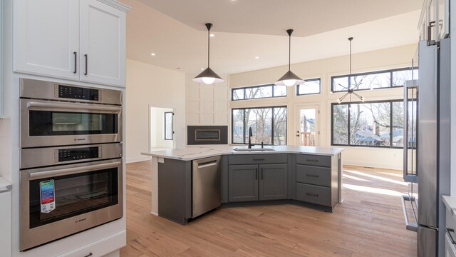 332 Arbor Ln, Saline, MI 48176 - kitchen with stainless steel appliances, light wood-style floors, gray cabinetry, a center island, and hanging light fixtures