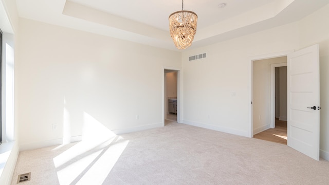 332 Arbor Ln, Saline, MI 48176 - spare room featuring a chandelier, light carpet, a tray ceiling, and a smoke detector