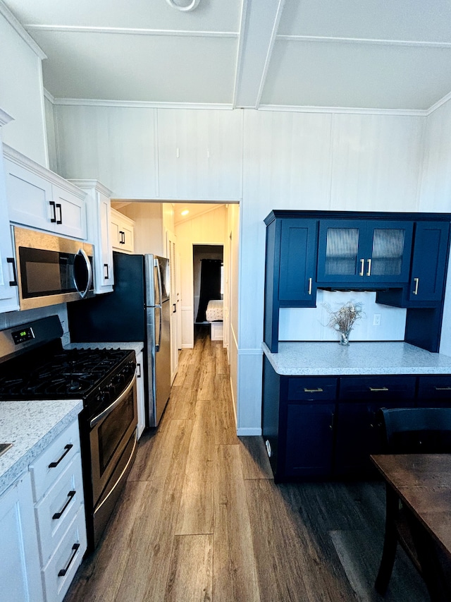 kitchen with hardwood / wood-style flooring, white cabinetry, blue cabinetry, and appliances with stainless steel finishes