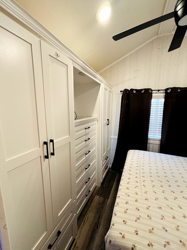 unfurnished bedroom with ceiling fan, dark hardwood / wood-style floors, lofted ceiling, and crown molding