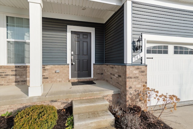 doorway to property featuring a porch and a garage