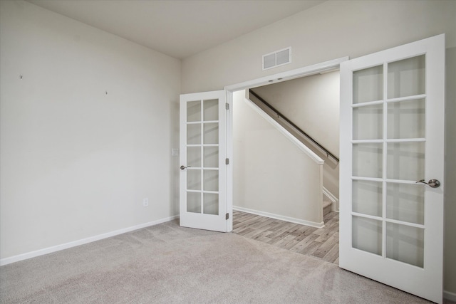 unfurnished room featuring light colored carpet and french doors