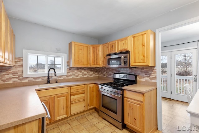 kitchen featuring decorative backsplash, a wealth of natural light, sink, and appliances with stainless steel finishes