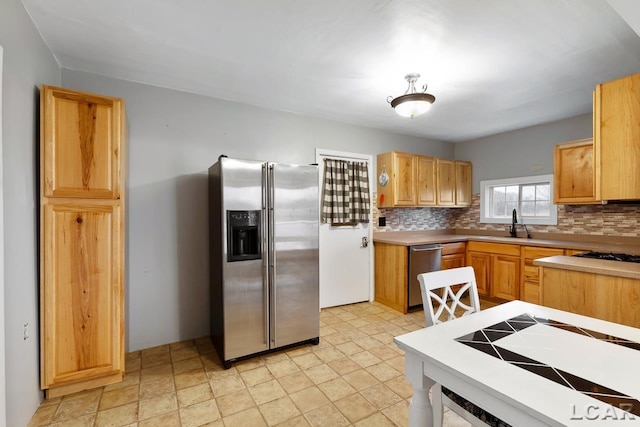 kitchen featuring decorative backsplash, sink, and stainless steel appliances