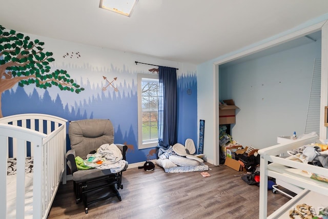 bedroom with hardwood / wood-style floors and a nursery area