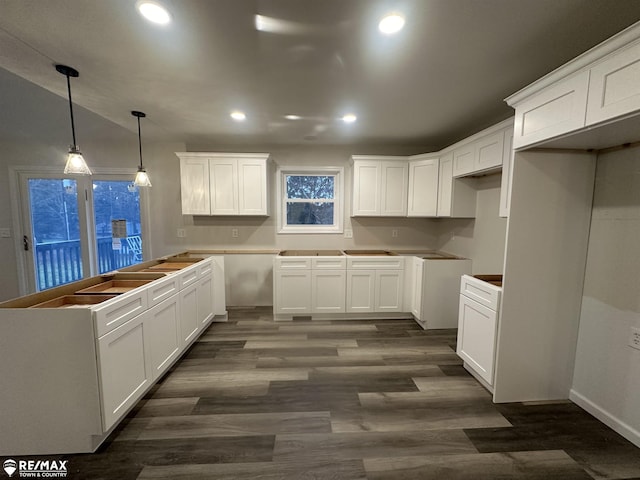 kitchen featuring dark hardwood / wood-style flooring, hanging light fixtures, and white cabinets