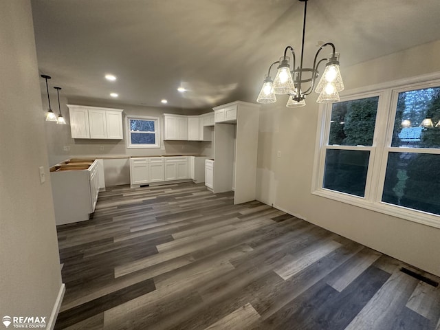 kitchen featuring white cabinetry, hanging light fixtures, and dark hardwood / wood-style floors