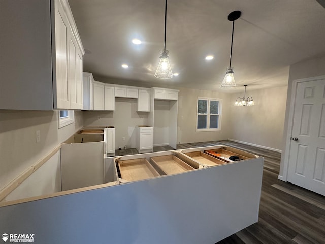 kitchen with white cabinetry, a kitchen island, pendant lighting, and dark hardwood / wood-style flooring