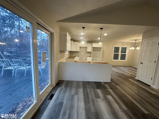 kitchen with a notable chandelier, decorative light fixtures, dark wood-type flooring, and white cabinets