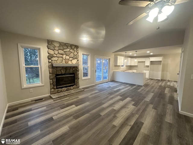 unfurnished living room featuring a fireplace, dark hardwood / wood-style floors, and plenty of natural light