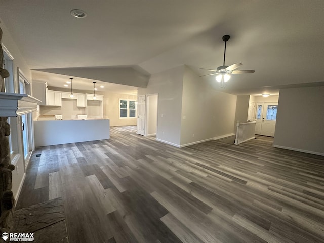 unfurnished living room featuring vaulted ceiling, dark wood-type flooring, and ceiling fan