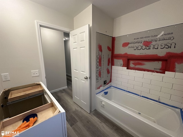 bathroom with a washtub, vanity, and hardwood / wood-style flooring