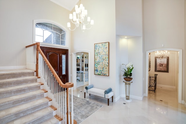 entryway featuring a towering ceiling and a notable chandelier