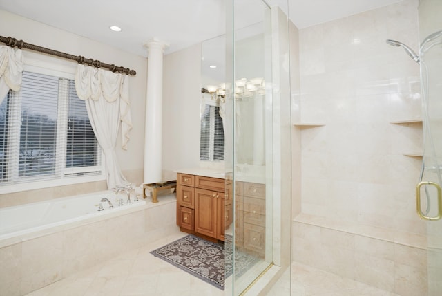 bathroom featuring independent shower and bath, tile patterned flooring, vanity, and decorative columns