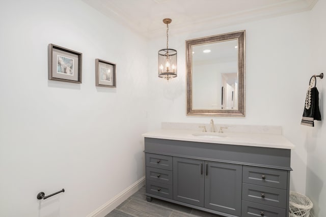 bathroom with vanity, crown molding, and a chandelier