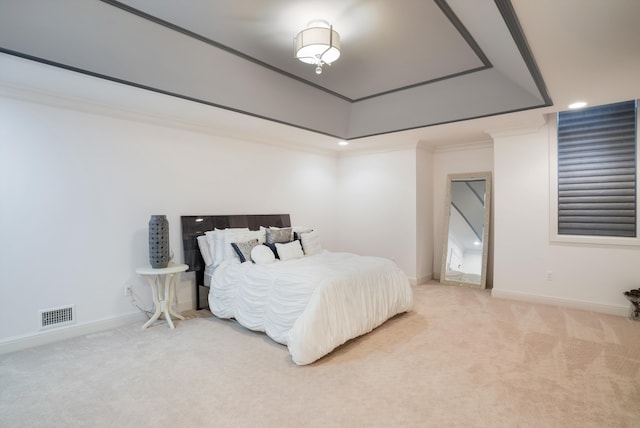 bedroom featuring carpet floors, a tray ceiling, and ornamental molding