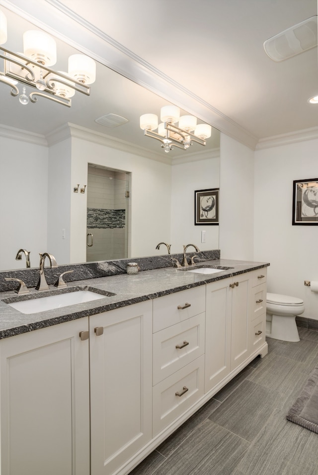 bathroom with vanity, toilet, ornamental molding, and an enclosed shower