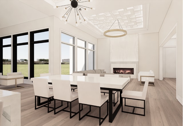 dining space with a notable chandelier, a large fireplace, and light hardwood / wood-style floors