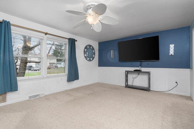 unfurnished living room with carpet flooring and ceiling fan