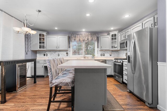 kitchen with a kitchen bar, decorative backsplash, a center island, and stainless steel appliances